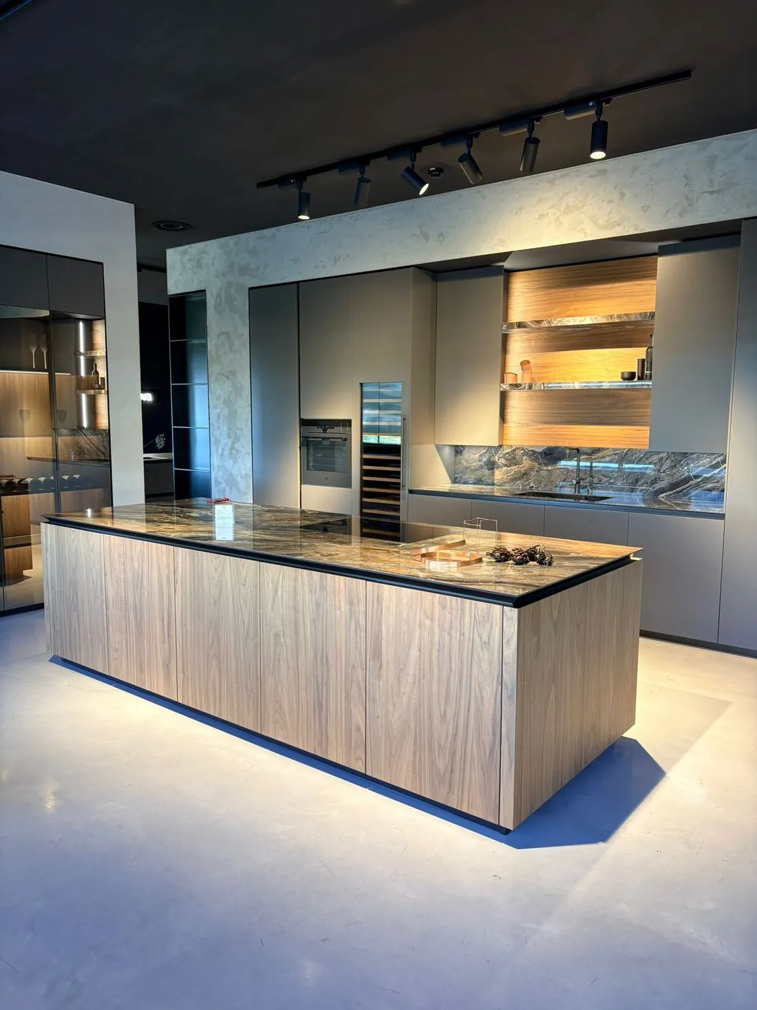 Îlot en noyer et plan de travail en céramique dans un showroom éclairé
